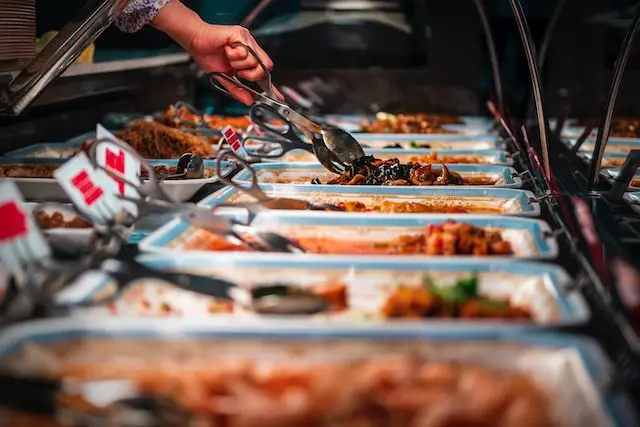 Image of hand serving food from the Buffet in Kitchener